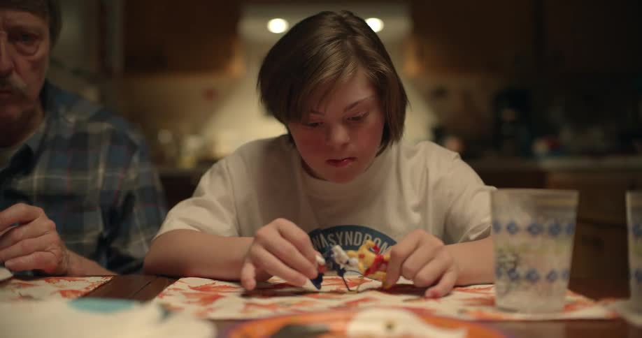A girl plays with hockey figurines at the dinner table
