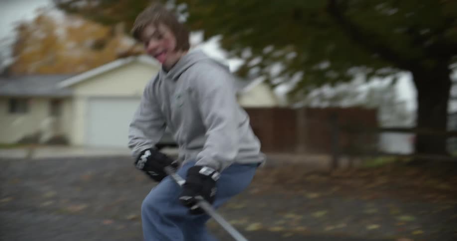 A girl cheers while making a goal playing street hockey