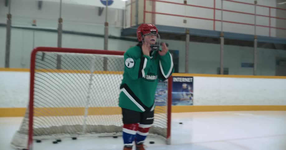 A girl playing goalie in a hockey game throws her stick gloves and helmets on the ice and skates away