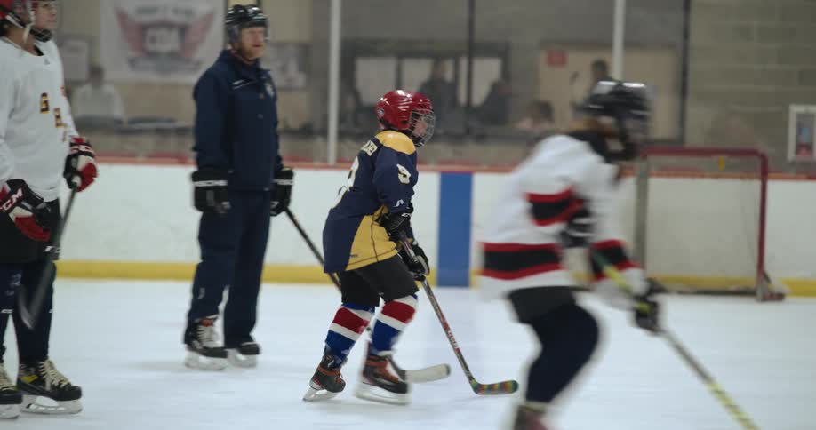 Trainers guide young hockey players in hockey rink