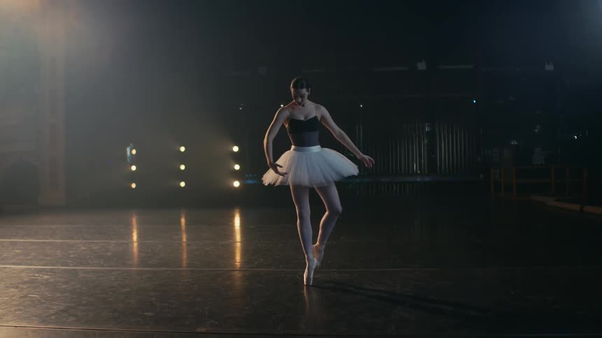 A woman is doing ballet in an empty room