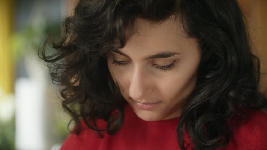 A woman is working on something as she looks down