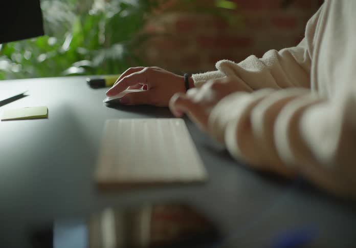 A woman is using her computer mouse