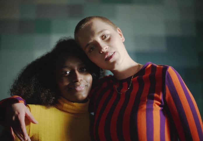 Friends stand and pose with arm arms around each other