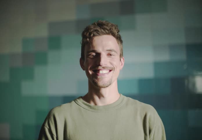 A young man is looking ahead and smiling