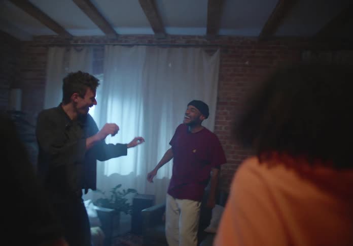 A group of friends dance around their apartment