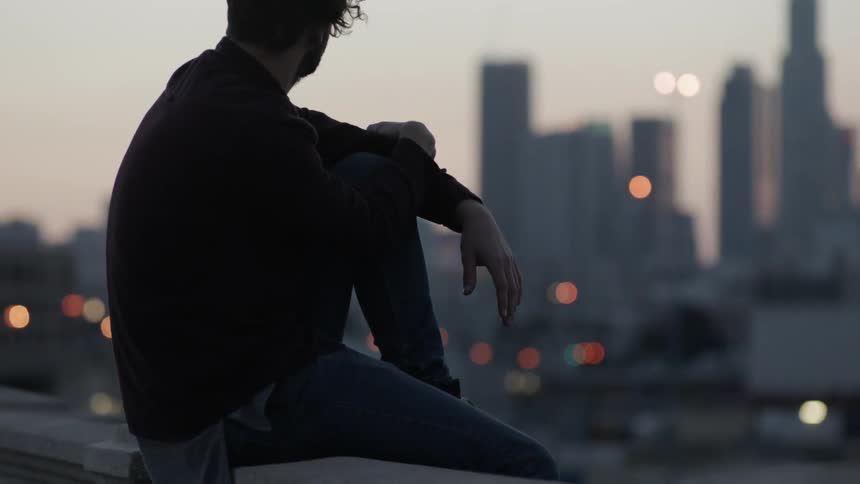A man looks out at a city skyline