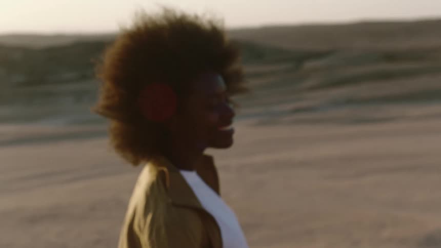 Model smiles and walks in the desert with a big smile on her face