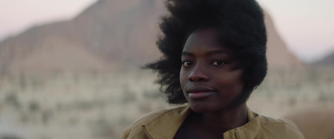 Close up young black female looking posing at the desert on a windy day