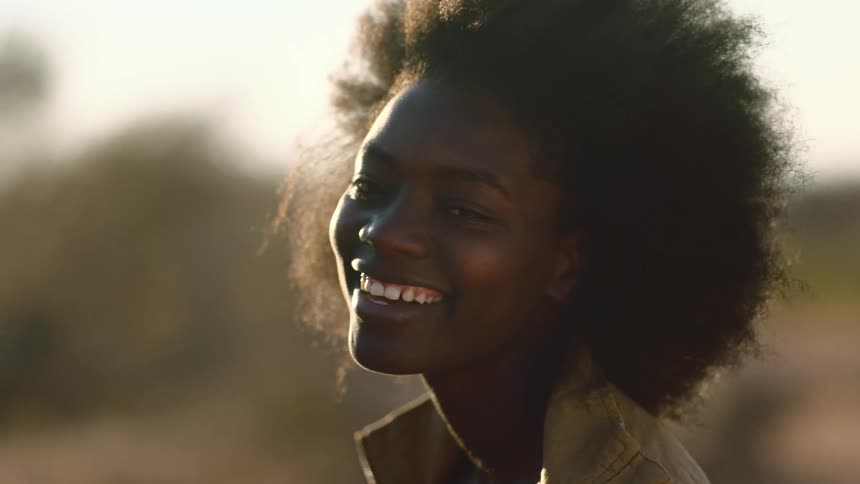 Happy portrait of black woman with sun flare