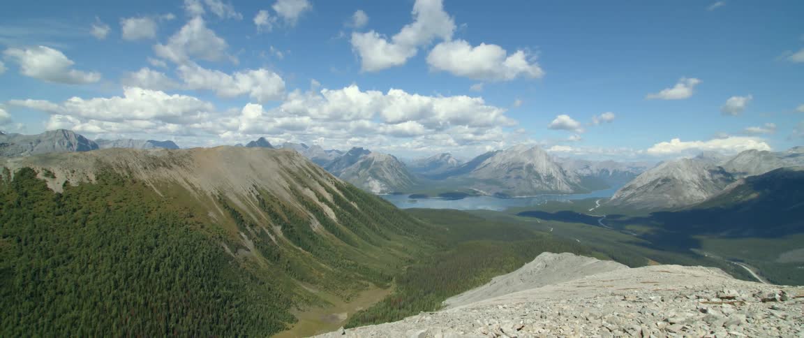 A river running between lush green and rocky mountain terrain on a gorgeous cloudy day