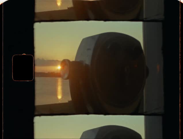 A tourist telescope overlooking a beach at sunset