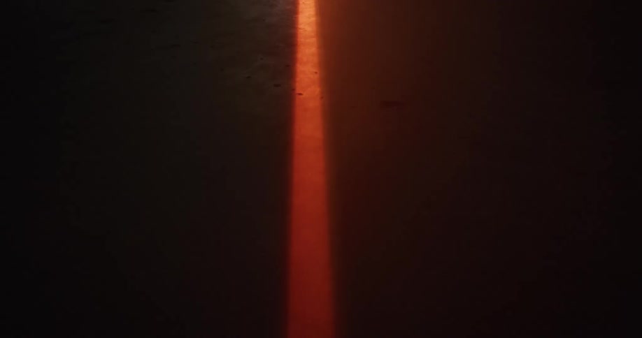 A bright orange line on the pavement glows at night