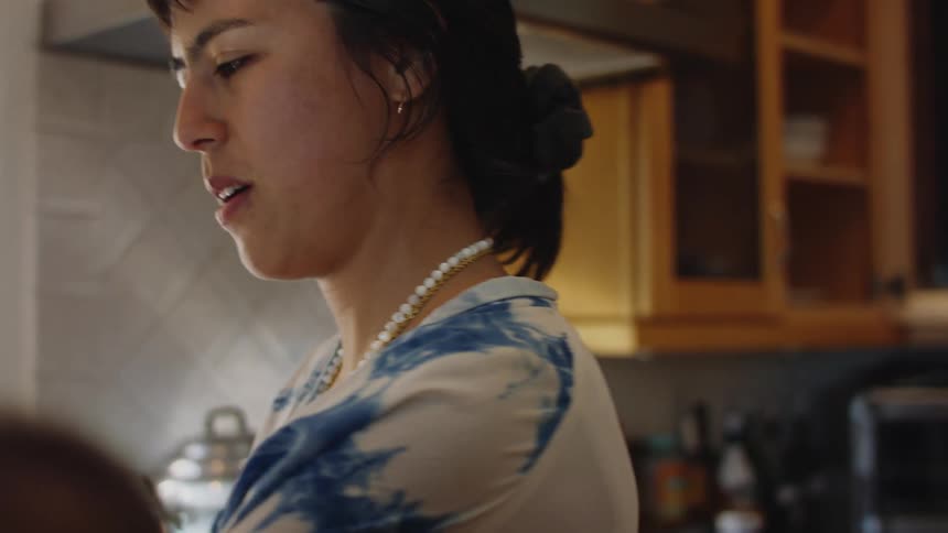 A woman is eating food in her kitchen