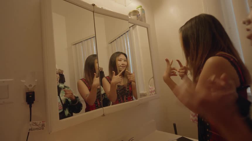 Two girls are putting on facial cream in a bathroom