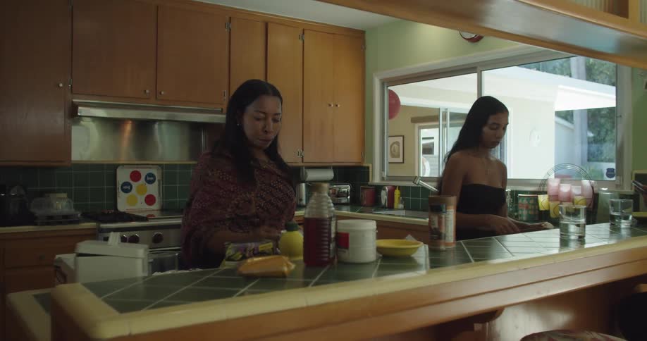 A family preparing food and drinking coffee while gathered in a home kitchen