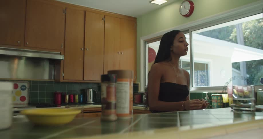 A young woman preparing food in a home kitchen