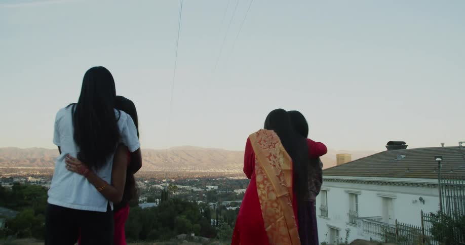 A group of people are hugging outdoors at dusk