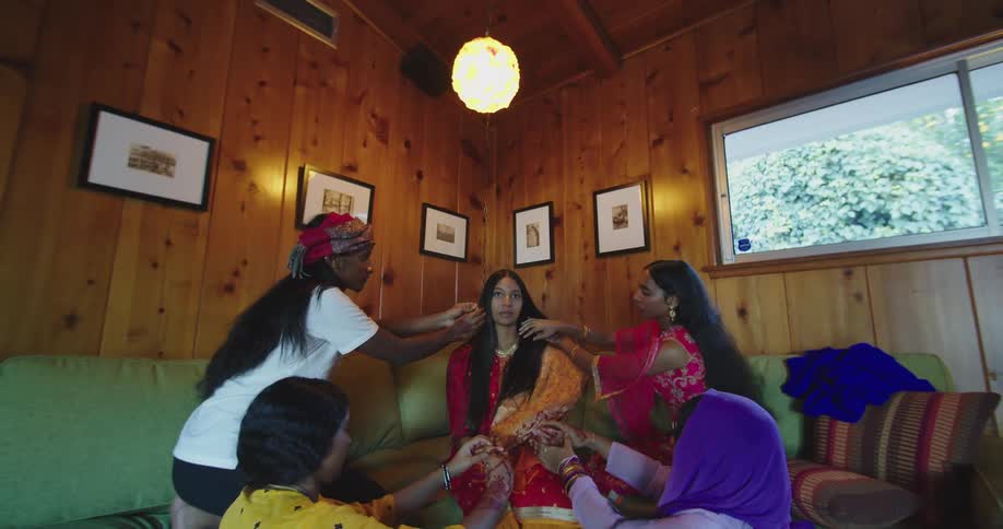 A group of people are styling a womans hair