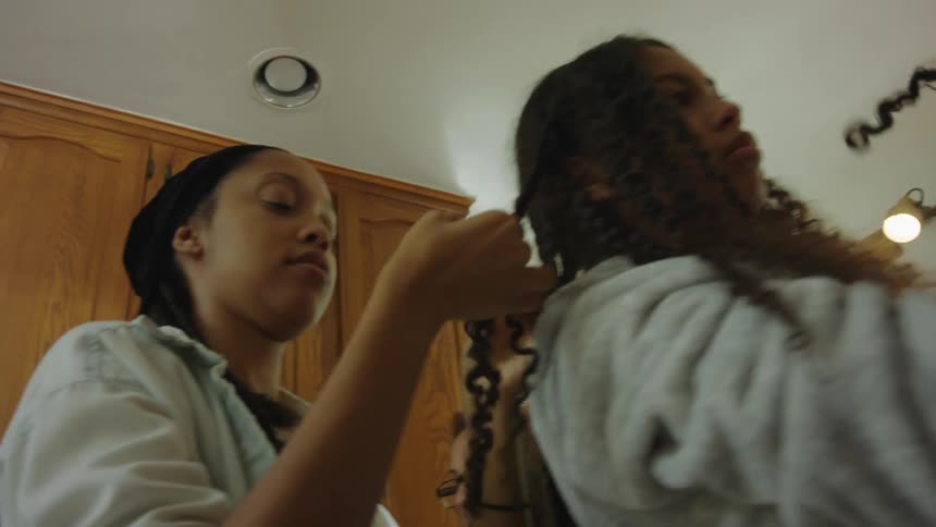 A group of girls with curly hair braids hair