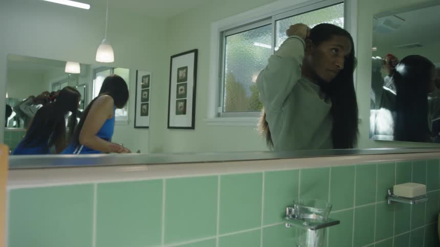 Two women get ready in bathroom and discuss jewelry to wear