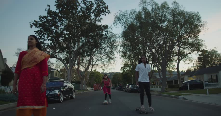 Group of female friends wearing indian traditional garments rolling on skateboards inthe neighborhood streets