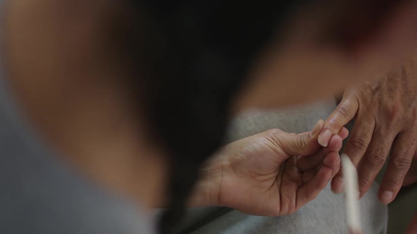 A woman is styling someones nails