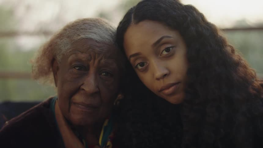 Grandmother and granddaughter looking at the camera at sunset