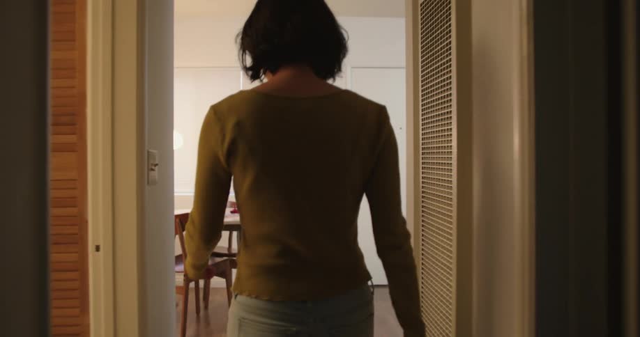 A woman walks into the room and touches her friends face