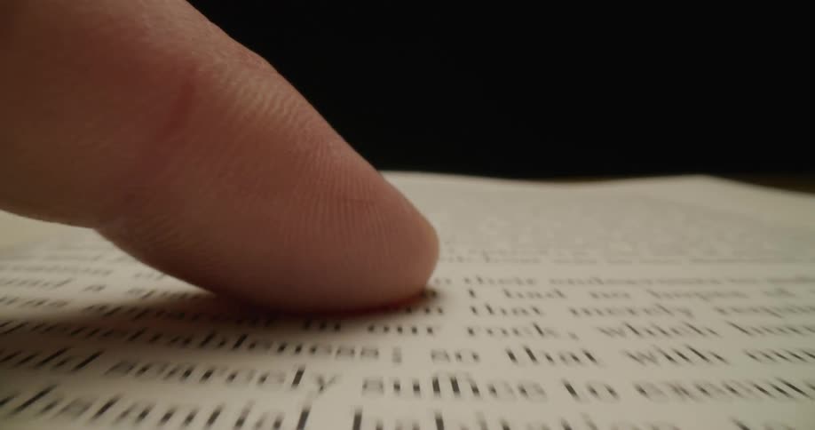 Someone moves their finger across the text on a page in a book