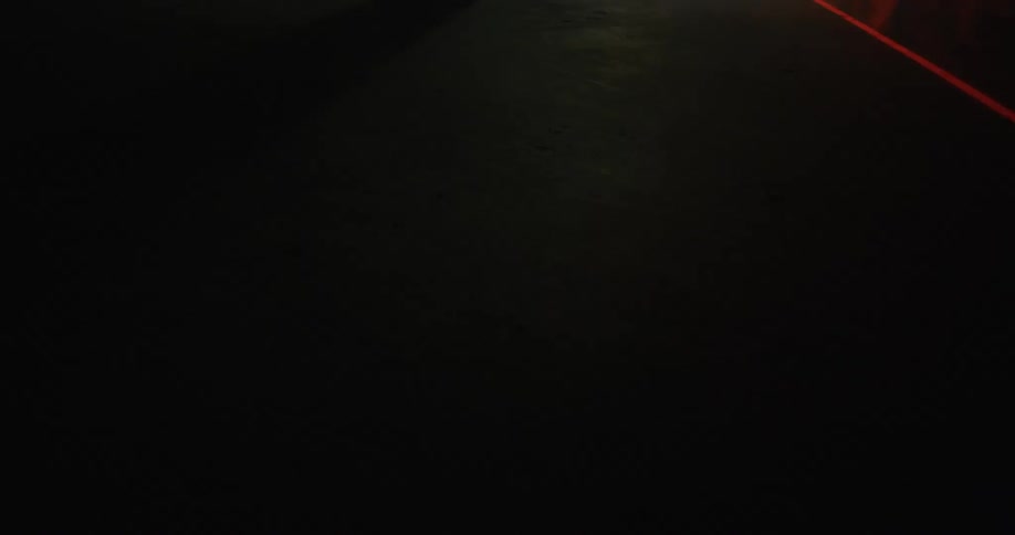 A bright orange line moves across the pavement