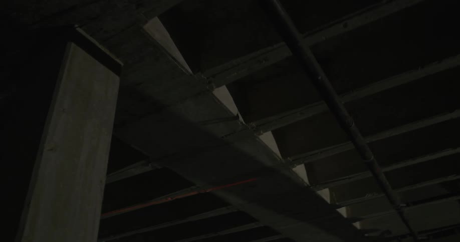 Red laser light scanning the roof walls and columns inside a dimly lit room