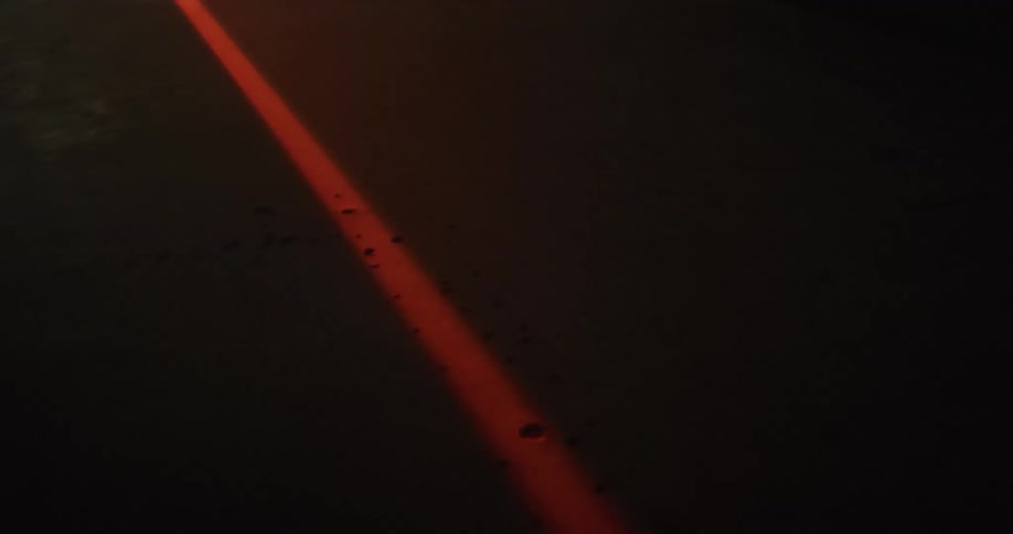 A bright red light is flashing outdoors at night