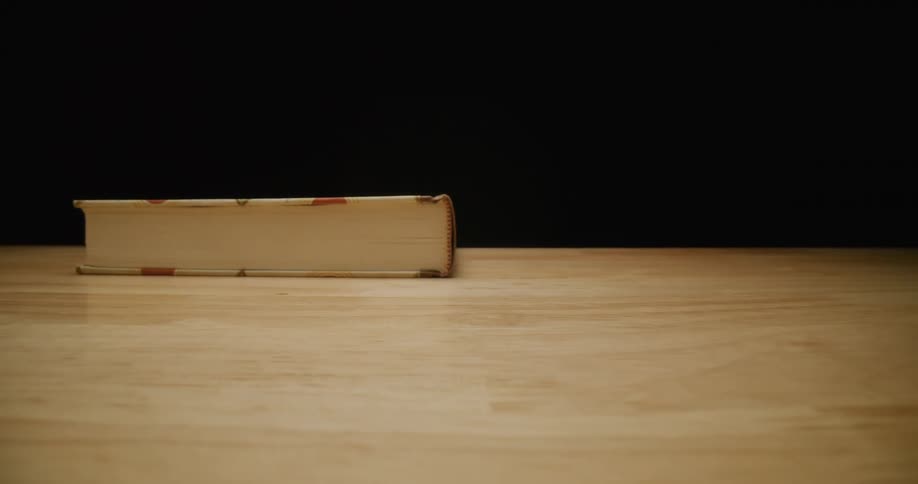 A person is closing a book and then walks away