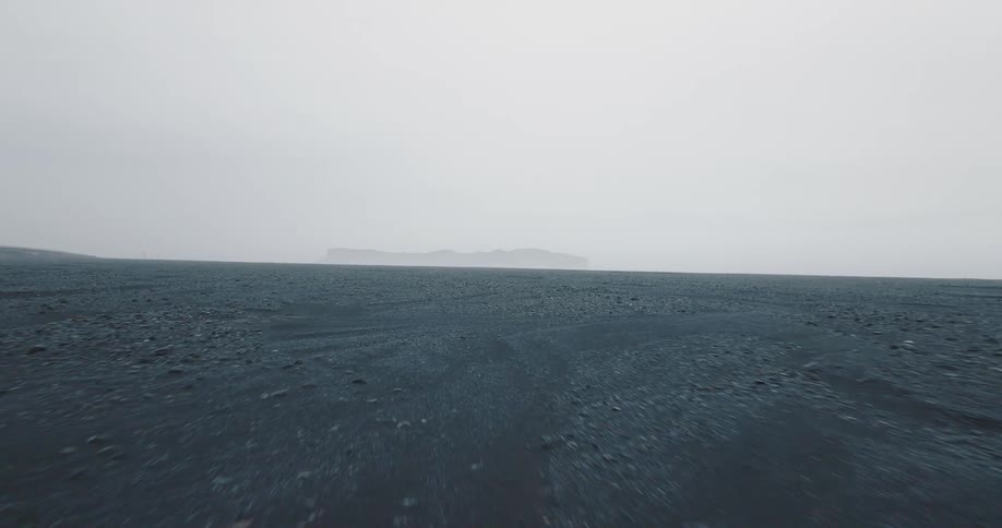 A muddy field with rocks on a foggy day