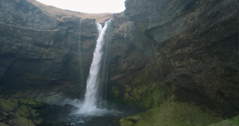 Aerial view of a waterfall is displayed at dusk