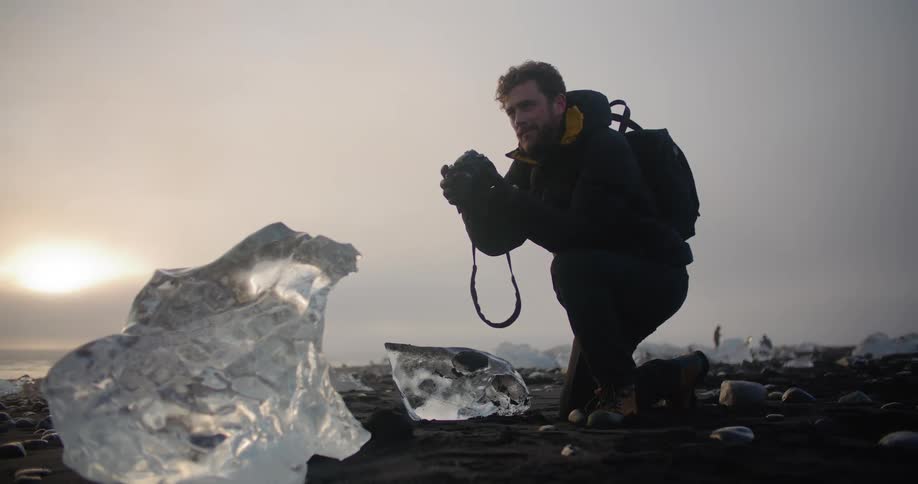 A man photographing a chunk of ice in nature