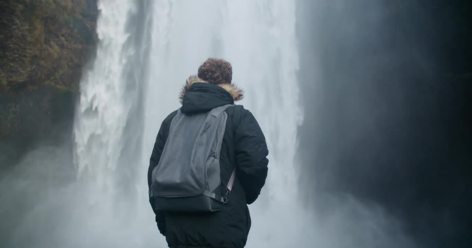 A man is looking at a waterfall