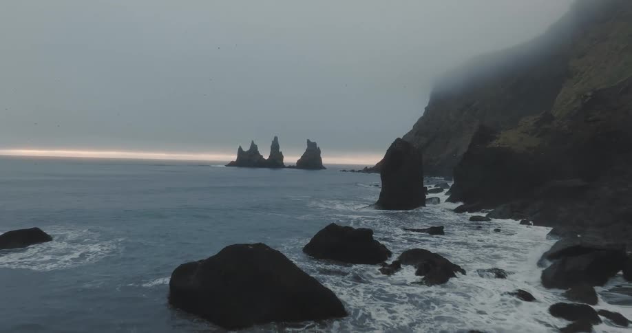 Aerial view of promontories under the mist on the reynisfjara black sand beach