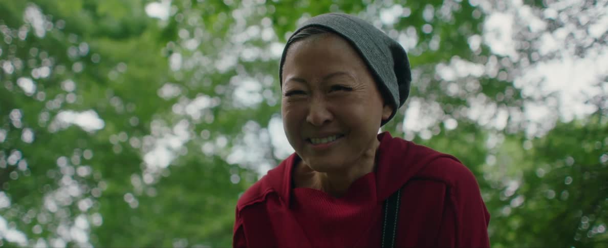 Happy smiling woman nodding at someone near the trees