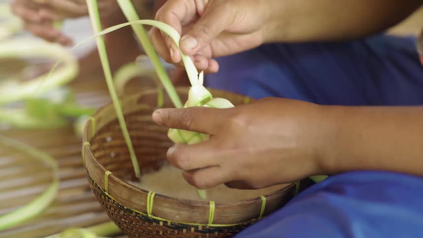 People pack rice into small woven boxes