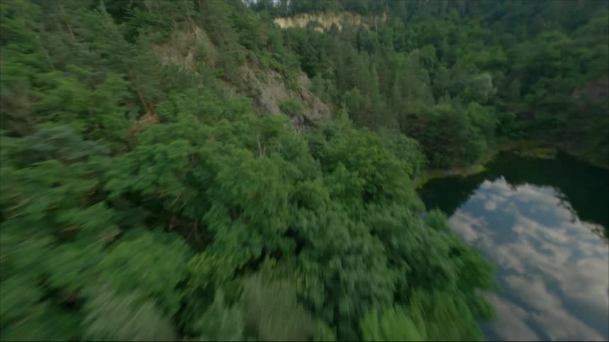 Aerial view of a small calm lake on a small valley between the mountains