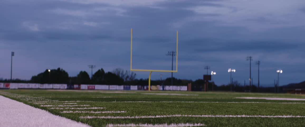 A football player falls out of bounds as he catches the ball