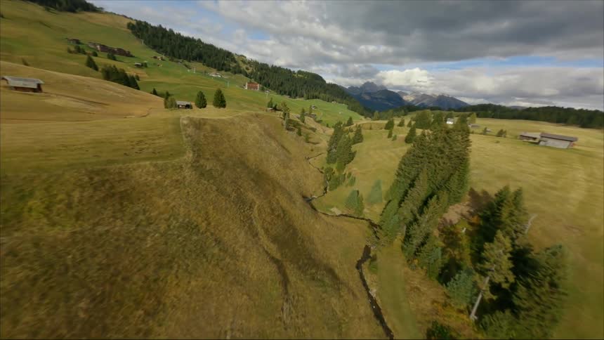 An aerial view of a river flowing in a valley surrounded by hills and forest in a rural area