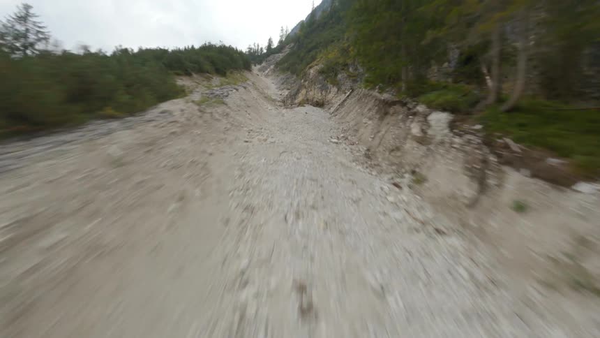 Empty track leads along mountain to cliff side overlooking valley