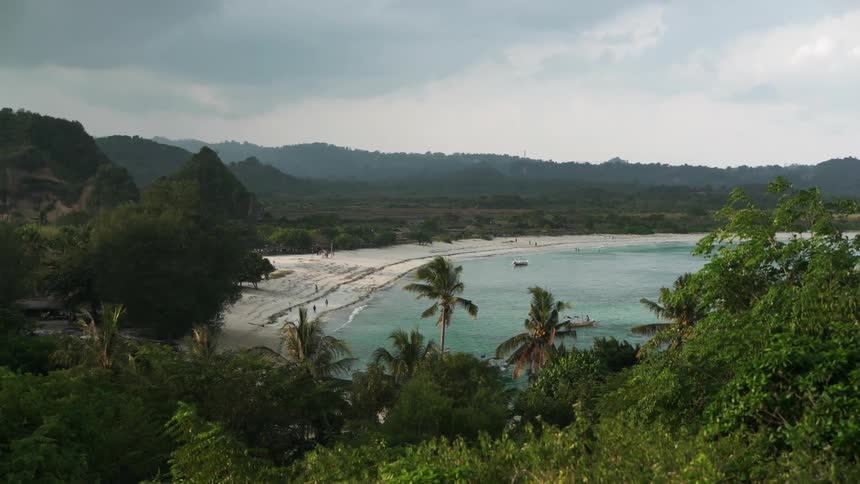 Aerial view of a coastline surrounded by trees and hills