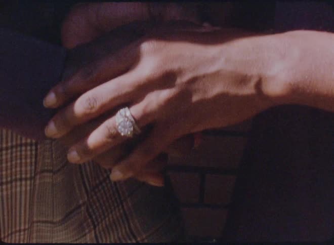 Two people hold hands outside