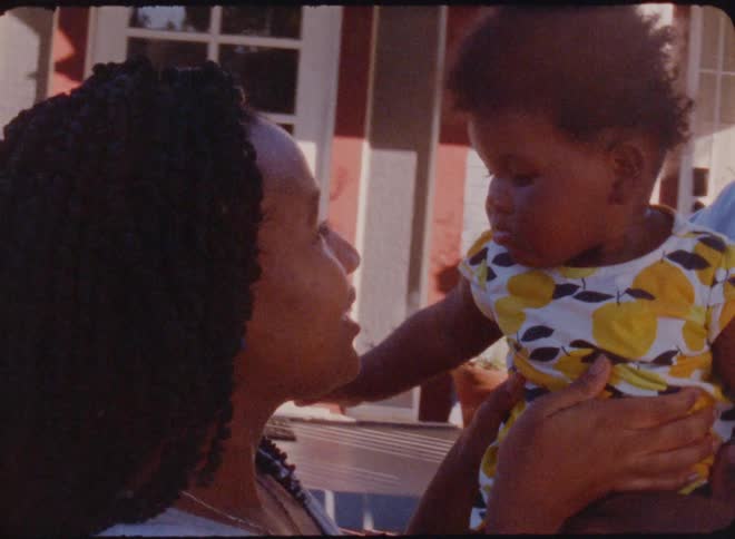 Parents hold their daughter in the yard