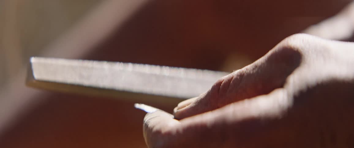 Tribal man making a bow and arrow