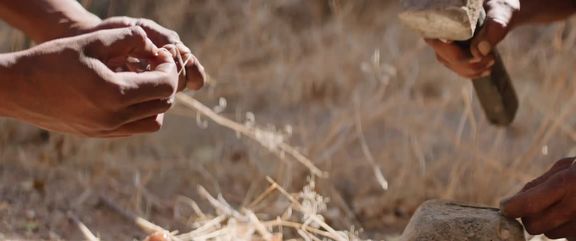 Tribal men hammer arrow to hunt in the field